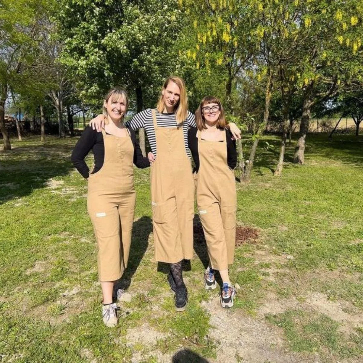 Teambuilding uključuje tri djelatnice u radnom odjelu smeđe boje.